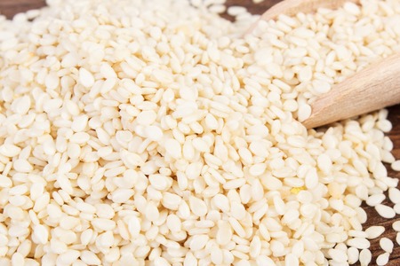 Heap of sesame seeds with wooden scoop, concept of healthy nutritionの写真素材