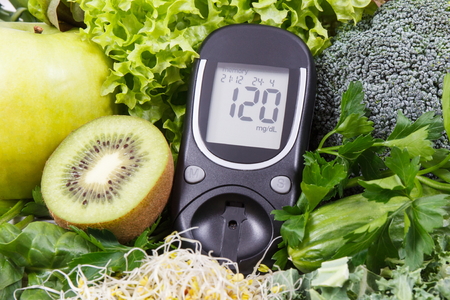 Glucometer for measuring sugar level and vegetables with sprouts as healthy nutritious food during diabetes containing vitamins and mineralsの写真素材