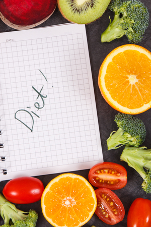 Word diet written in notepad and fresh ripe fruits with vegetables, concept of healthy lifestyles and nutritionの写真素材