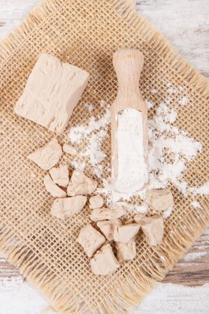 Fresh dry crumbled yeast and flour as ingredients for cooking and bakingの写真素材