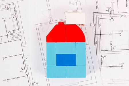 Colorful plastic toy blocks and construction drawings of house. Concept of buying or renting homeの写真素材