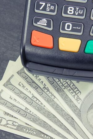 Payment terminal and currencies dollar. Finance concept and choice between cashless or cash paying in different placesの写真素材