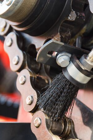 Metal chain with brush as detail and part of agricultural or industrial machinery. Technology conceptの写真素材