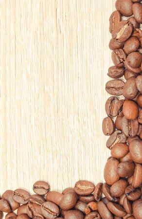 Heap of roasted coffee grains on wooden board. Place for text or inscriptionの写真素材