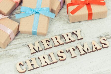 Wrapped gifts with colorful ribbons for Christmas lying on old rustic board