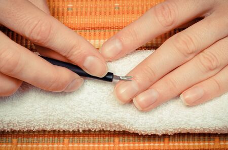 Woman trimming cuticles of hand. Care of hands and manicure conceptの写真素材