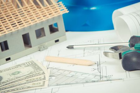 Electrical construction drawings, work tools and accessories for use in engineer jobs, small house and currencies dollar, building home cost conceptの写真素材