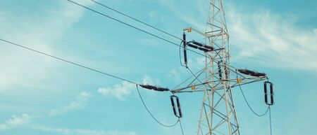 High voltage electric pole with wires on blue sky background. Line of electricity transmissions and...