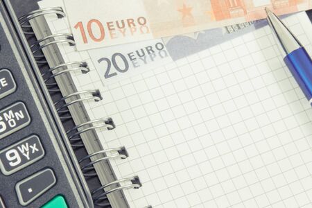 Payment terminal, notepad for writing notes and money. Business concept. Copy space for text or inscriptionの写真素材