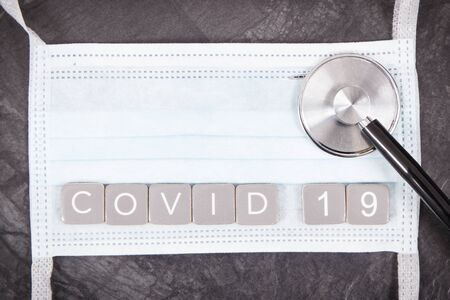 Inscription covid-19 with surgical or protective mask and stethoscope. Novel coronavirus outbreak. 2019-nCoV. Sars-CoV-2の写真素材