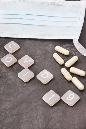 Inscription covid 19 with surgical or protective mask and tablets. Novel coronavirus outbreak. 2019-nCoVの写真素材