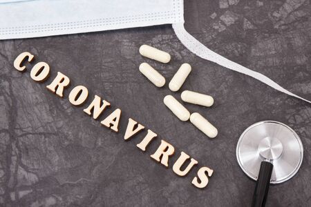 Inscription coronavirus with surgical or protective mask, tablets and stethoscope. Novel coronavirus...