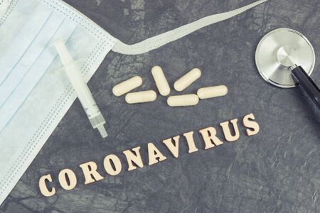 Inscription coronavirus with surgical or protective mask, tablets, syringe and stethoscope. Novel Chinese coronavirus outbreak. 2019-nCoVの写真素材