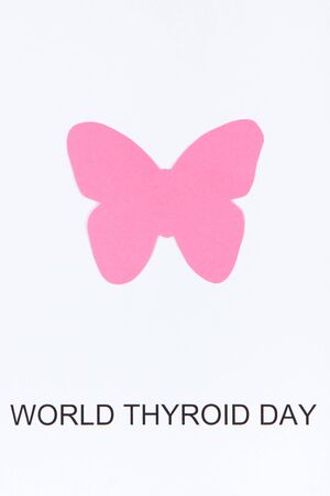 Pink thyroid shape made of paper and inscription World Thyroid Day. Problems with thyroid. White...