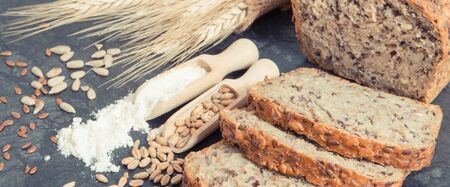 Fresh baked wholegrain bread, ingredients for baking and ears of rye or wheat grain