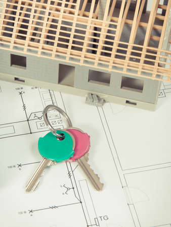 Home keys, house under construction and electrical diagrams for engineer jobs
