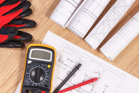 Diagrams and electrical construction drawings, protective gloves and multimeter for measurement in electrical installation, accessories for engineer jobsの写真素材