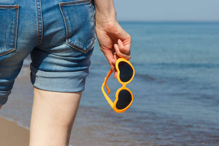 Hand of woman with sunglasses in shape of heart. Summer and vacation time