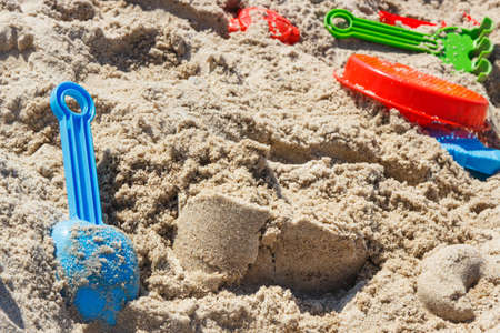 Different shapes made of sand and children toys for relax or playing on summer beach. Vacation time and child developmentの写真素材