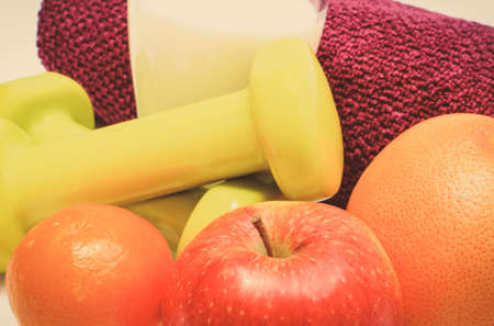 Fresh ripe fruits and dumbbells using in fitness. Slimming, healthy nutrition and sporty lifestyles