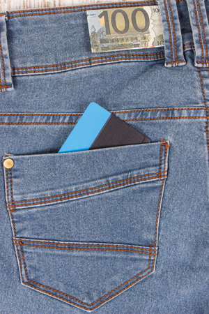 Money and credit card in pocket of blue pants. Finance and banking conceptの写真素材