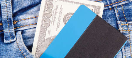 Dollar and credit card in front jeans pocket. Concept of cashless or cash paying for shoppingの写真素材
