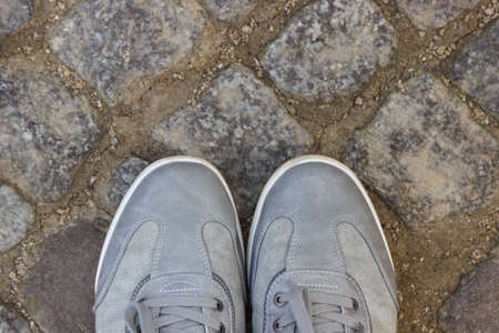 Comfortable gray leather shoes for men on footpath made of rocks or stones. Male footwear