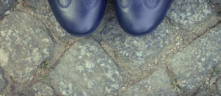 Comfortable navy blue leather shoes for men on footpath made of rocks or stones. Male footwear. Copy...