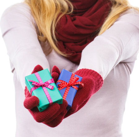 Hand of woman in woolen gloves holding wrapped gifts for Christmas, Valentine, birthday or other...