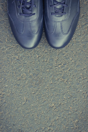 Comfortable casual navy blue leather shoes for men on asphalt road or footpath. Male footwear. Copy space for text or inscriptionの写真素材