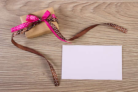Gift with ribbon and love letter for Valentines Day. Decoration for Valentines. Wooden backgroundの写真素材