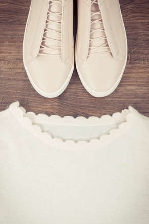 Vintage photo, Womanly pink leather shoes and woolen sweater lying on rustic boardsの写真素材