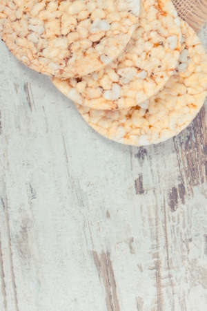 Puffed rice or corn waffles on old rustic board, concept of healthy nutrition, copy space for text...