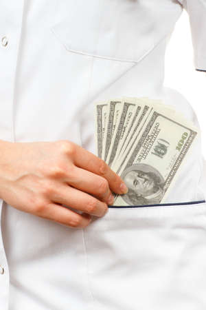 Woman doctor with stethoscope and currencies dollar in apron pocket, paying for medical care,...
