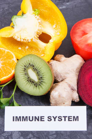Inscription immune system with fresh fruits and vegetables. Source natural vitamins, minerals and dietary fiberの写真素材