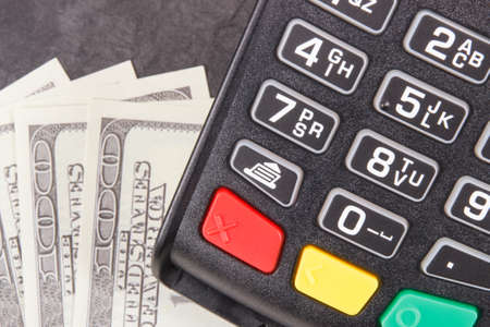 Payment terminal, credit card reader and money. Concept of cashless or cash paying for shopping