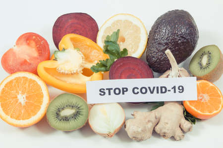 Inscription stop covid-19 and fresh ripe fruits with vegetables. Source natural healthy vitamins and minerals. Beneficial eating in times of Covid-19の写真素材