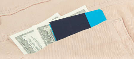 Dollar and credit card in back trousers pocket. Concept of cashless or cash paying for shoppingの写真素材