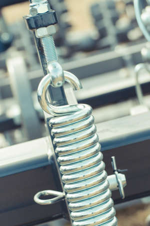 Big and hard silver steel spring as part and detail of industrial or agricultural machine.の写真素材