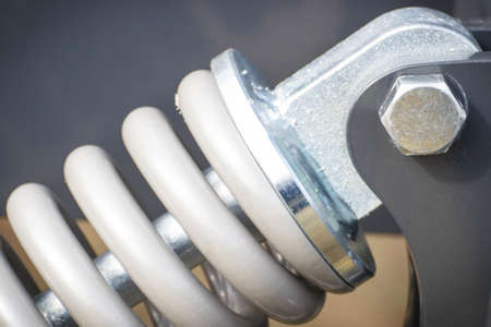 Hard gray spring made of steel. Part of big industrial or agricultural machine.の写真素材