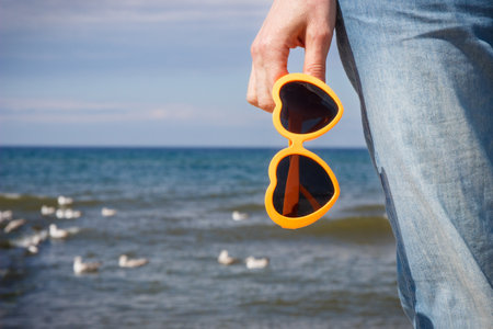 Hand of woman with sunglasses in shape of heart. Summer and vacation time