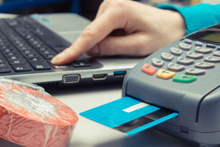 Payment terminal with credit card in shop. Cashless paying for shoppingの写真素材