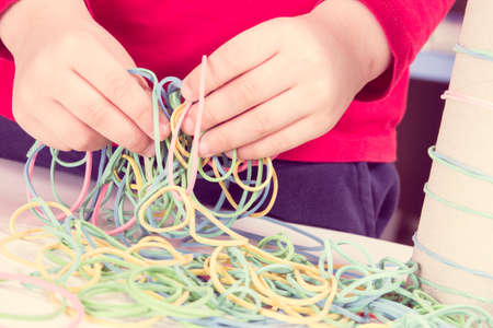 Preschooler playing with colorful rubber erasers and cardboard roll.の写真素材
