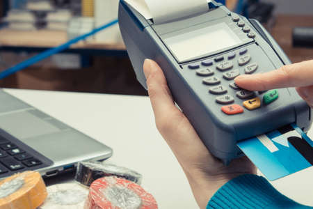 Payment terminal with credit card in shop. Cashless paying for shopping. Finance and banking conceptの写真素材