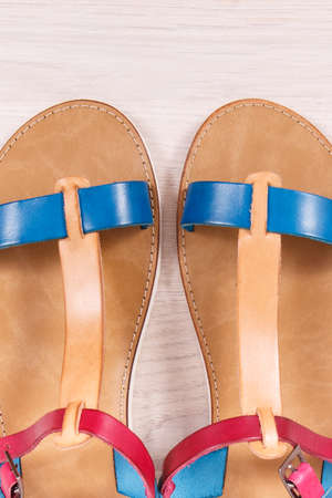Fashionable and comfortable leather sandals for woman lying on white boardの写真素材