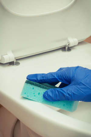 Hand of cleaner using brush for cleaning toilet in bathroom. Household dutiesの写真素材