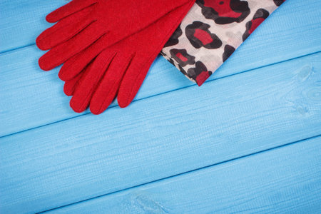 Woolen gloves and colorful shawl for woman, womanly accessories, warm clothing for autumn or winter, copy space for text on boardsの写真素材