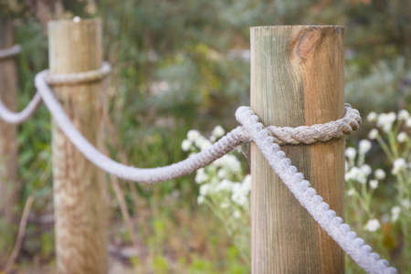 Fence made of rope and wooden pole in public parkの写真素材