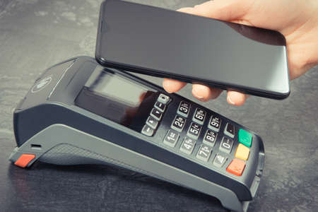 Credit card reader and mobile phone using for cashless paying. Payment terminal. Finance and banking conceptの写真素材