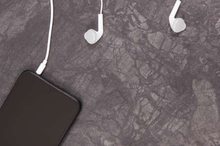 Mobile phone, smartphone with headphones. Relaxation time with music. Using electronics equipment....